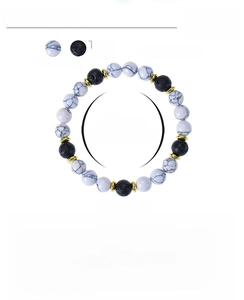 Detailed view of 8mm white turquoise and black volcanic stone beads with gold spacers