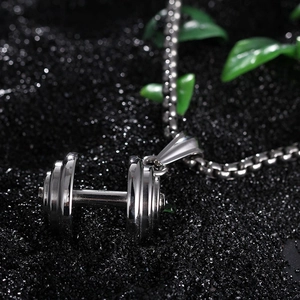 Collier pendentif haltère en acier inoxydable poli pour homme sur fond noir texturé
