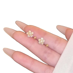 Elegant gold flower stud earrings with cubic zirconia stones shown in a macro close-up view