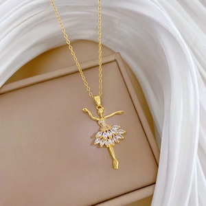 Elegante collana dorata con ciondolo ballerina e cristalli su una scatola per gioielli