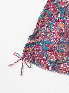 Detail of vibrant paisley print swimwear featuring adjustable side drawstring bow design