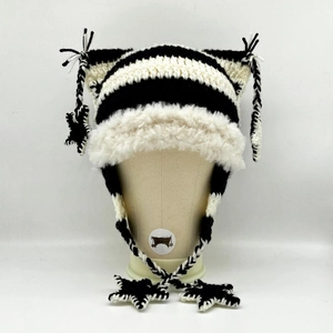 Detail of hand-knitted cat ear hat with black and white stripes and star pendants