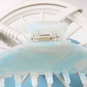Macro shot of large acrylic hair claw clip with blue gradient and gold glitter detail