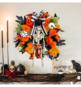 Halloween wreath with skull, pumpkin, and maple leaves on a white wall decor