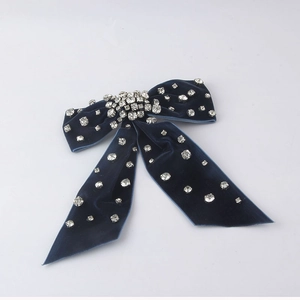 Close-up of luxury dark blue velvet bow hair clip with sparkling rhinestones details