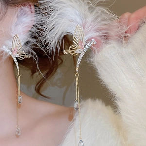 Detail of butterfly tassel earrings with pink rhinestones and soft white feathers