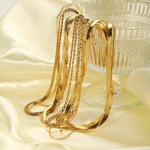Elegant 18K gold-plated double-layer titanium necklaces hanging on a glass with silk fabric