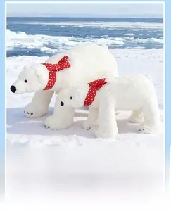 Close-up of white polar bear plush toys featuring red scarves with a polar ice background