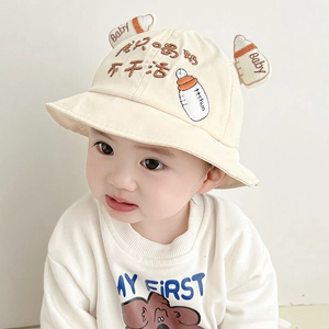 Close-up of beige baby bucket hat featuring playful milk bottle patch and cute embroidery