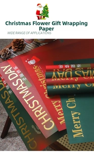 Detailed texture of thick red and green Christmas wrapping paper with gold foil lettering