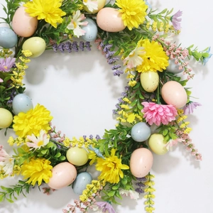 Colorful Easter wreath with spring flowers and speckled eggs for home door decoration