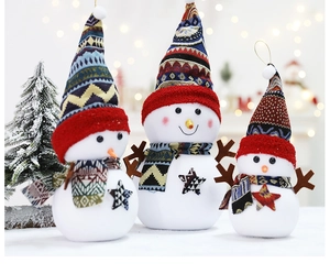 Detailed view of plush Christmas snowmen in three sizes with ethnic patterns and warm lighting