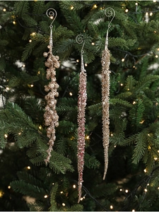 Detailed view of champagne and rose gold sequin tassel ornaments hanging on a Christmas tree