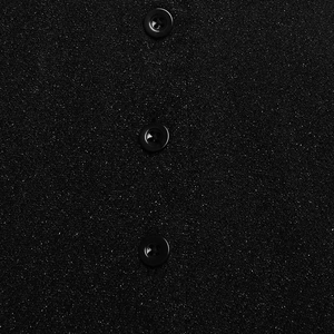 Macro shot of black textured fabric with glitter details and three round buttons