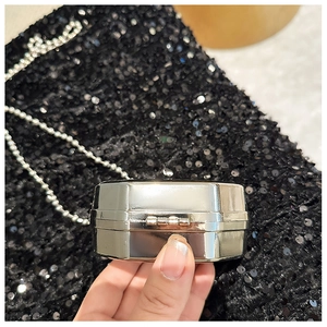 Detail view of mini silver metal bag with polished finish and sturdy side hinges