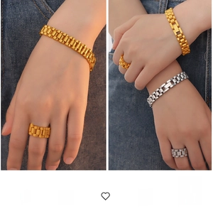 Close-up of gold and silver watch-band style chain bracelets and rings on a model hand
