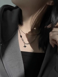 Detail of double-layered titanium steel necklace with black pendant on male model