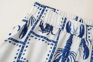 Close-up of elastic waistband on white trousers with blue lobster and grid pattern