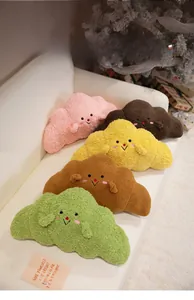 Plush croissant-shaped pillows in five colors on a sofa with Christmas decor