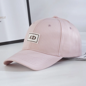 Close-up of pink baseball cap featuring AD letter embroidery and six-panel structure