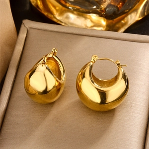 Detailed close-up of chunky U-shape gold earrings with a polished surface on a tray