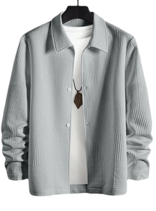 Detail of grey jacquard jacket with geometric herringbone pattern and buttoned lapel