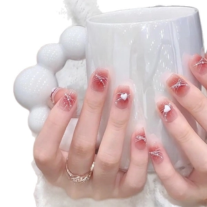 Short square press-on nails with red blush gradient design and 3D heart charms