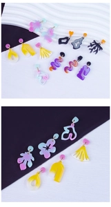 Assorted geometric acrylic earrings in vibrant colors displayed on a textured surface