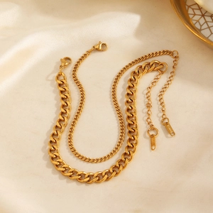 Gold double-layered Cuban and curb link anklet displayed on premium beige silk fabric