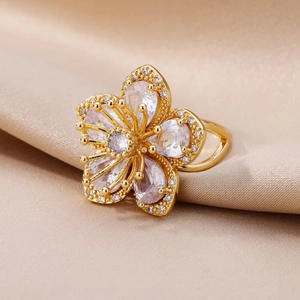 Elegant gold flower ring with sparkling clear cubic zirconia on soft silk fabric
