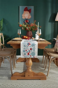 Detailed Christmas table runner with snowflake, bell, and reindeer patterns on a wooden table