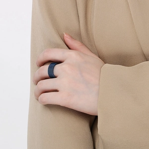 Detail of a dark blue mesh texture metal ring with a wide industrial grid band design