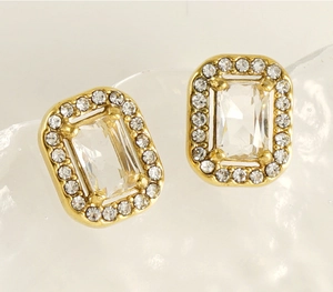 Detailed view of gold rectangle stud earrings with zircon stones and diamond accents