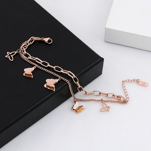 Detail eines Roségold-Doppelkettenarmbands mit matten und hohlen Schmetterlingsanhängern