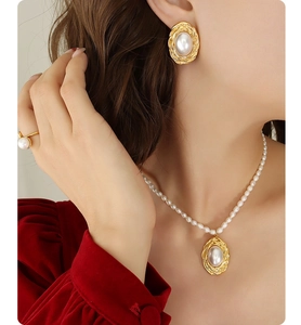 Detail of elegant gold-plated oval freshwater pearl earrings and matching necklace set