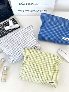 Three checkered fabric toiletry bags in blue and yellow patterns for travel storage