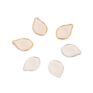 Macro detail of acrylic petal charms with gold and silver edges for DIY jewelry making