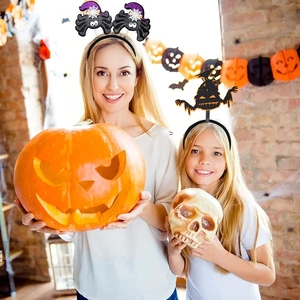 Femme et fille portant des serre-têtes d'Halloween avec motifs fantôme et sorcière