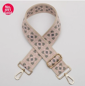Close-up of geometric jacquard bag strap in pink and grey with golden lobster clasps
