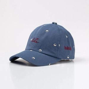 Detail view of dark blue cotton baseball cap with red embroidered Hola cursive lettering