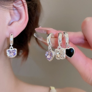 Detailed view of elegant silver butterfly and heart drop earrings with purple crystals