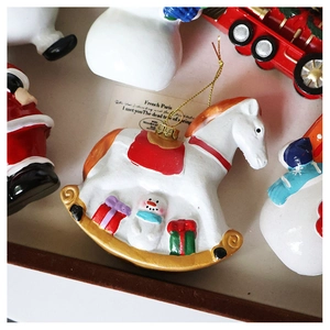 Detailed close-up of a white Christmas rocking horse ornament with snowman and gift patterns