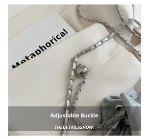 Close-up of adjustable metal ball buckle and silver-grey leather woven chain strap