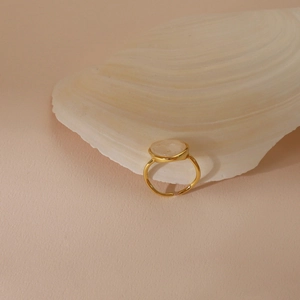 Detail of adjustable 925 silver ring with opal-like crystal on white shell background