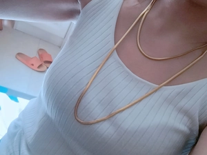 Close-up of gold snake bone chain necklaces in long and short lengths on a person