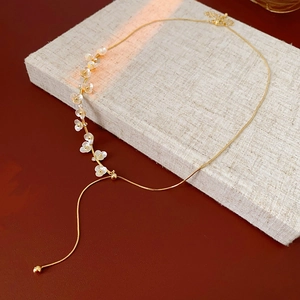 Detail of flower pearl necklace with gold plating on beige fabric surface