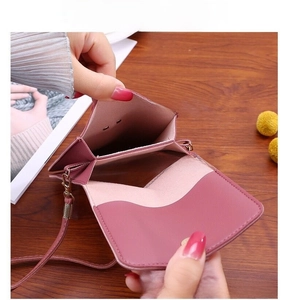 Detail of dusty pink mini crossbody phone bag with multi-layer interior and gold buckle