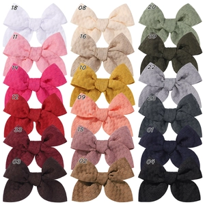 Set of 18 colorful 3.3-inch jacquard fabric bow hair clips in a grid display