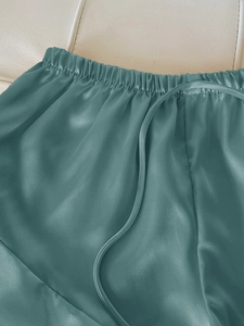 Detail of teal silk pajama shorts with elastic waistband and drawstring detail