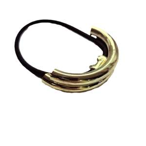 Macro detail of U-shaped golden metal hair ring with high-elastic black rubber band
